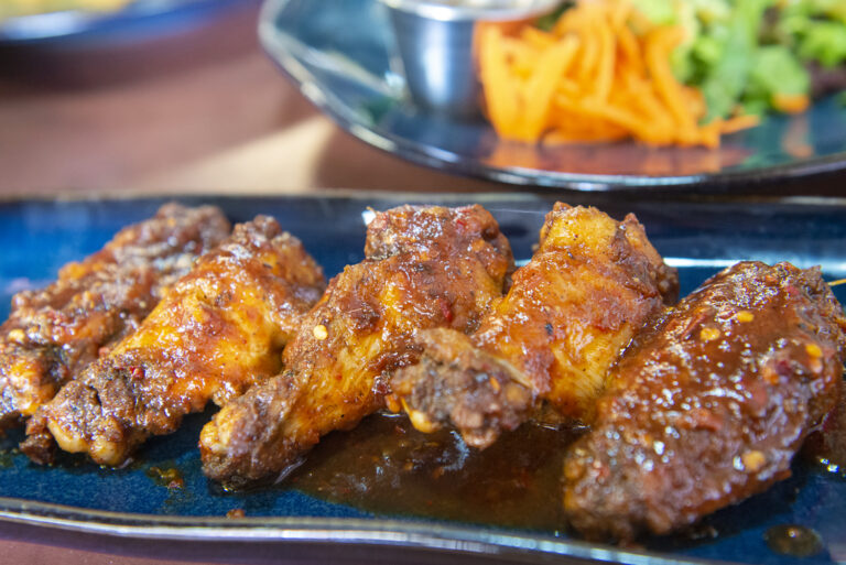 Plate of glazed jerk chicken wings at Reggae Pot Jamaican Grill